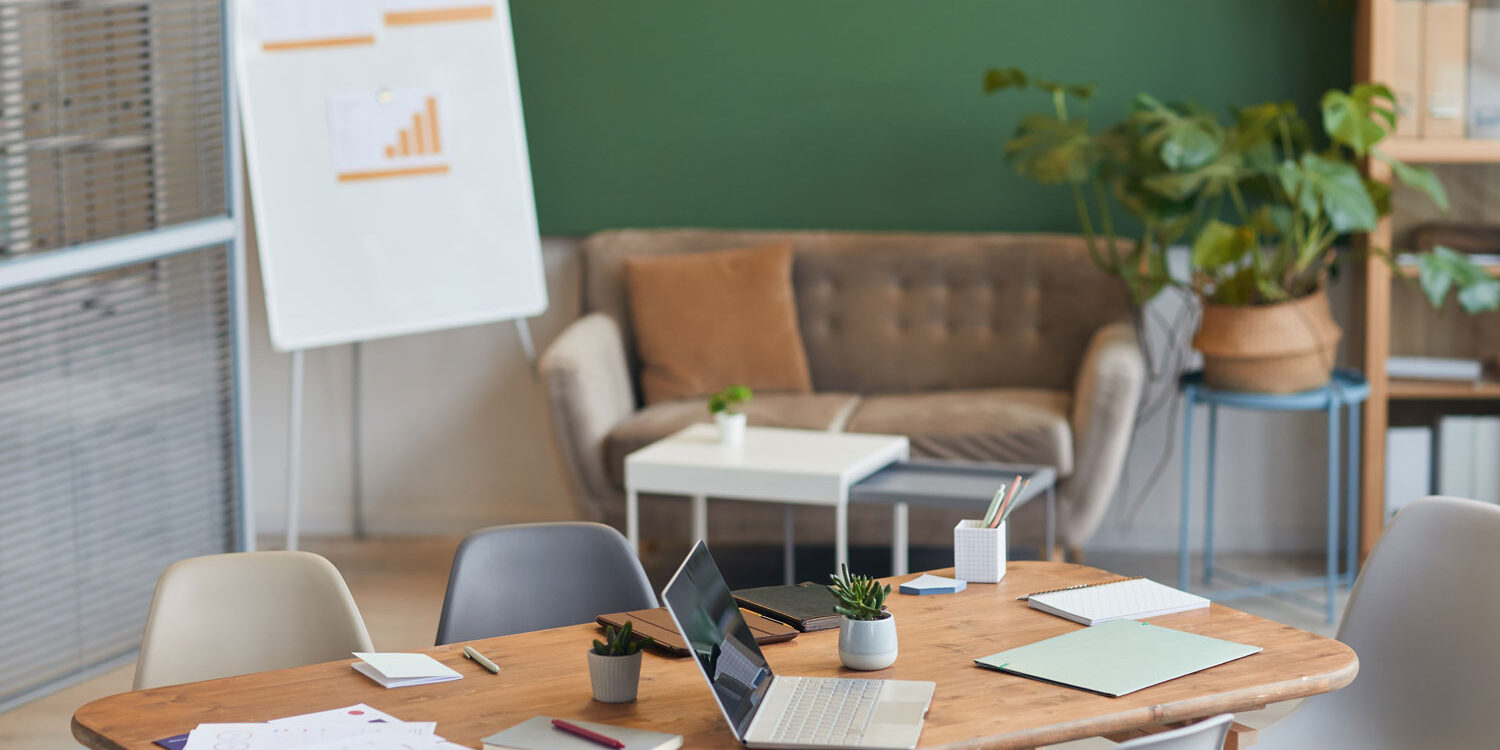 Bright friendly office with a table for people to gather at.